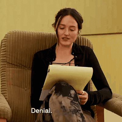 A Woman Is Sitting In A Chair Holding A Piece Of Paper And The Word Denial Is Next To Her GIF