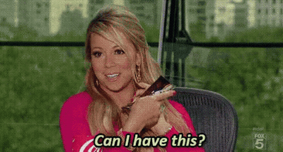 A Woman Is Sitting In A Chair Holding A Remote Control And Asking , Can I Have This ? GIF