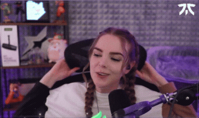 A Woman Is Sitting In A Chair In Front Of A Microphone And Adjusting Her Hair . GIF