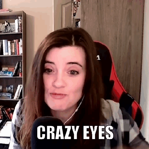 A Woman Is Sitting In A Chair In Front Of A Microphone And Says Crazy Eyes . GIF