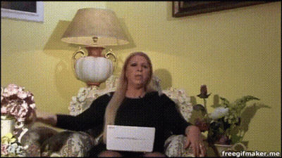 A Woman Is Sitting In A Chair With A Laptop In Front Of Her And A Lamp Behind Her GIF