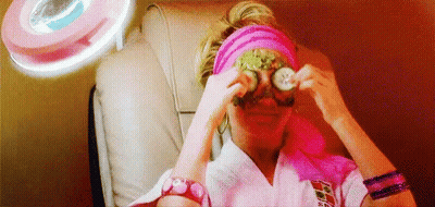 A Woman Is Sitting In A Chair With A Mask On Her Eyes . GIF