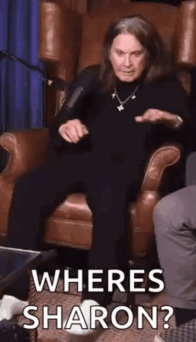 A Woman Is Sitting In A Chair With A Microphone And Asking Where Is Sharon ? GIF
