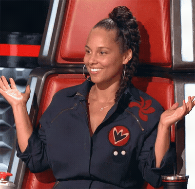 A Woman Is Sitting In A Chair With Her Arms Outstretched And Smiling GIF