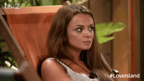 A Woman Is Sitting In A Chair With Her Eyes Closed . GIF