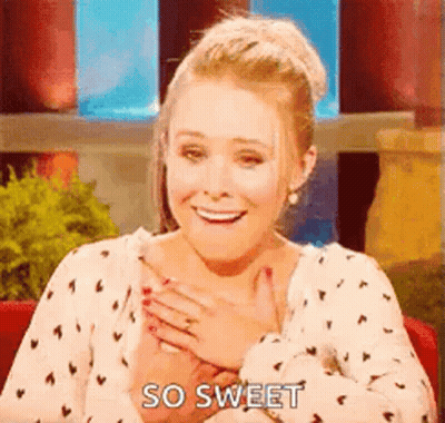 A Woman Is Sitting In A Chair With Her Hands On Her Chest . GIF