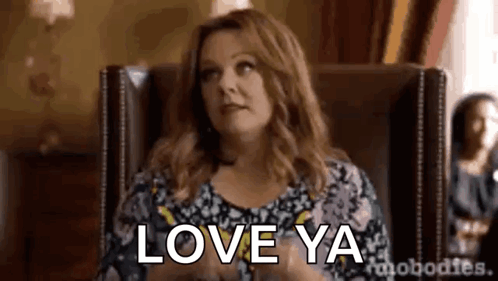 A Woman Is Sitting In A Chair With The Words `` Love Ya '' Written On It . GIF