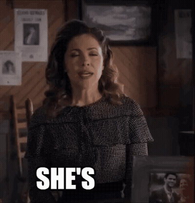 A Woman Is Sitting In A Chair With The Words She 'S Quirky Written On Her Face . GIF