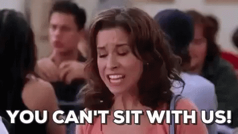 A Woman Is Sitting In A Crowd Of People And Saying `` You Can T Sit With Us ! '' GIF
