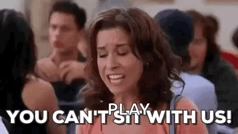 A Woman Is Sitting In A Crowd Of People With The Words `` You Can 'T Sit With Us '' Written On Her Face . GIF