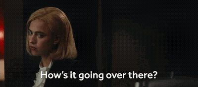 A Woman Is Sitting In A Dark Room Talking To Someone . GIF