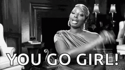 A Woman Is Sitting In A Living Room With Her Arms Outstretched And Says `` You Go Girl '' . GIF