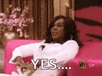 A Woman Is Sitting In A Pink Chair And Saying `` Yes '' . GIF