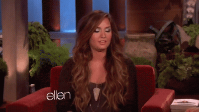 A Woman Is Sitting In A Red Chair With The Word Ellen On The Bottom GIF