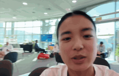 A Woman Is Sitting In A Room With A Lot Of Windows GIF