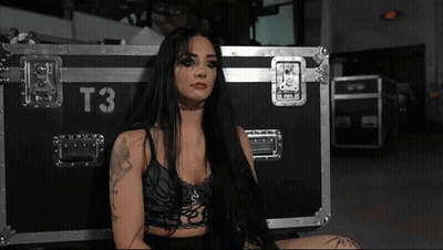 A Woman Is Sitting In Front Of A Case With The Number T3 On It GIF