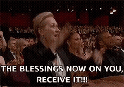 A Woman Is Sitting In Front Of A Crowd With Her Arms In The Air And Says `` The Blessings Now On You Receive It ! '' GIF