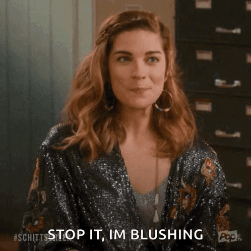 A Woman Is Sitting In Front Of A Filing Cabinet And Making A Funny Face . GIF