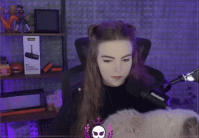 A Woman Is Sitting In Front Of A Microphone And A Box That Says ' Shure ' On It . GIF