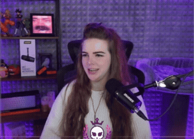 A Woman Is Sitting In Front Of A Microphone And A Box That Says ' Shure ' On It GIF