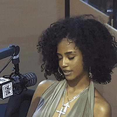 A Woman Is Sitting In Front Of A Microphone With A Box That Says Fox GIF