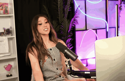 A Woman Is Sitting In Front Of A Microphone With A Laptop In Front Of Her And A Sign That Says ' Nothing ' GIF