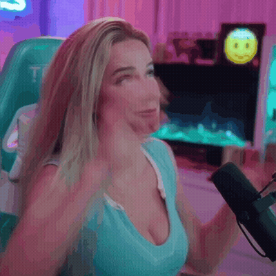 A Woman Is Sitting In Front Of A Microphone With A Smiley Face On The Screen Behind Her . GIF