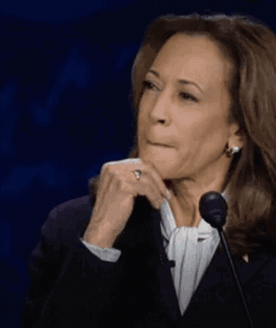 A Woman Is Sitting In Front Of A Microphone With Her Hand On Her Chin And A Ring On Her Finger . GIF