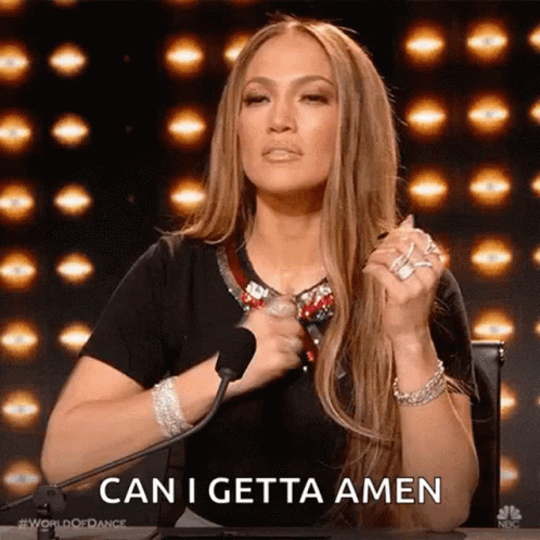 A Woman Is Sitting In Front Of A Microphone With Her Hands Folded In Prayer And Says `` Can I Getta Amen '' . GIF