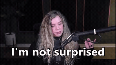 A Woman Is Sitting In Front Of A Microphone With The Words `` I 'M Not Surprised '' Written On The Screen . GIF