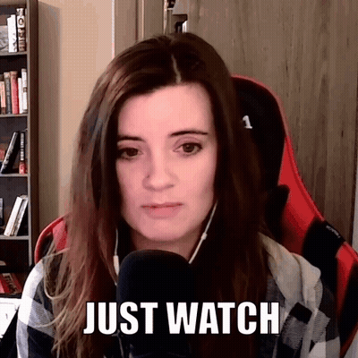 A Woman Is Sitting In Front Of A Microphone With The Words Just Watch Above Her Head . GIF