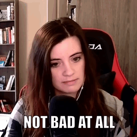 A Woman Is Sitting In Front Of A Microphone With The Words `` Not Bad At All '' On Her Face . GIF