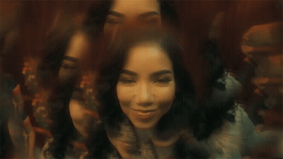 A Woman Is Sitting In Front Of A Mirror With Her Eyes Closed And A Blurry Background . GIF