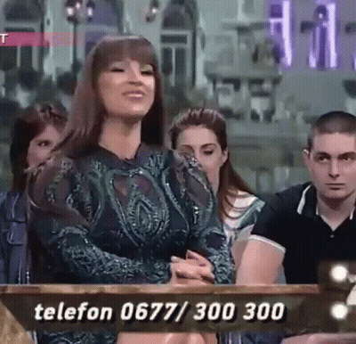A Woman Is Sitting In Front Of A Table With A Phone Number Written On It . GIF