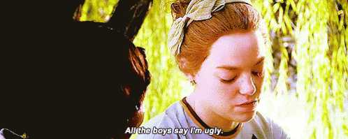 A Woman Is Sitting In Front Of A Tree And Talking To A Man . GIF