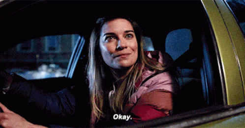 A Woman Is Sitting In The Back Seat Of A Car And Says Okay . GIF