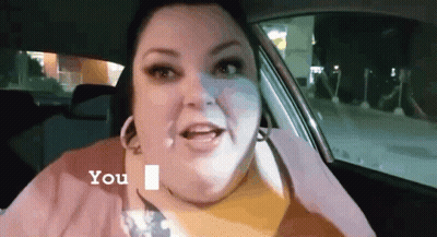 A Woman Is Sitting In The Back Seat Of A Car And Talking To Someone . GIF
