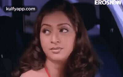 A Woman Is Sitting In The Back Seat Of A Car . GIF