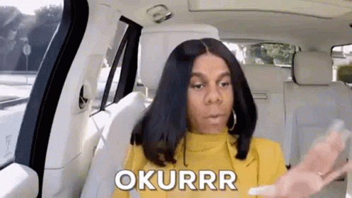 A Woman Is Sitting In The Back Seat Of A Car Talking On A Cell Phone . GIF