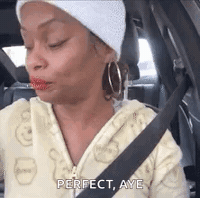 A Woman Is Sitting In The Back Seat Of A Car With A Seat Belt On . GIF