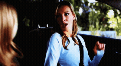A Woman Is Sitting In The Back Seat Of A Car With Her Mouth Open . GIF