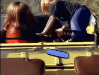 A Woman Is Sitting In The Back Seat Of A Yellow Car . GIF