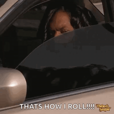 A Woman Is Sitting In The Driver 'S Seat Of A Car And Looking Out The Window . GIF