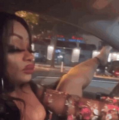 A Woman Is Sitting In The Driver 'S Seat Of A Car And Making A Funny Face . GIF