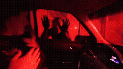 A Woman Is Sitting In The Driver 'S Seat Of A Ford Car . GIF