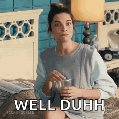 A Woman Is Sitting On A Bed Holding A Glass Of Water And Saying Well Duh . GIF