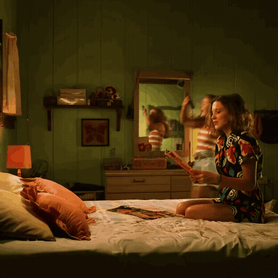 A Woman Is Sitting On A Bed Reading A Book Called " A Brief History Of The World " GIF