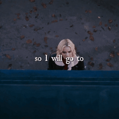 A Woman Is Sitting On A Blue Bench With The Words So I Will Go To Written Below Her GIF