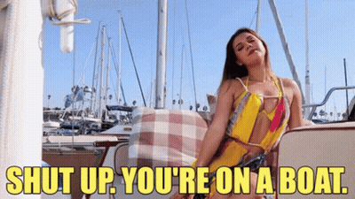 A Woman Is Sitting On A Boat With The Words Shut Up You 'Re On A Boat GIF
