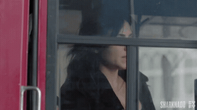 A Woman Is Sitting On A Bus Looking Out The Window . GIF